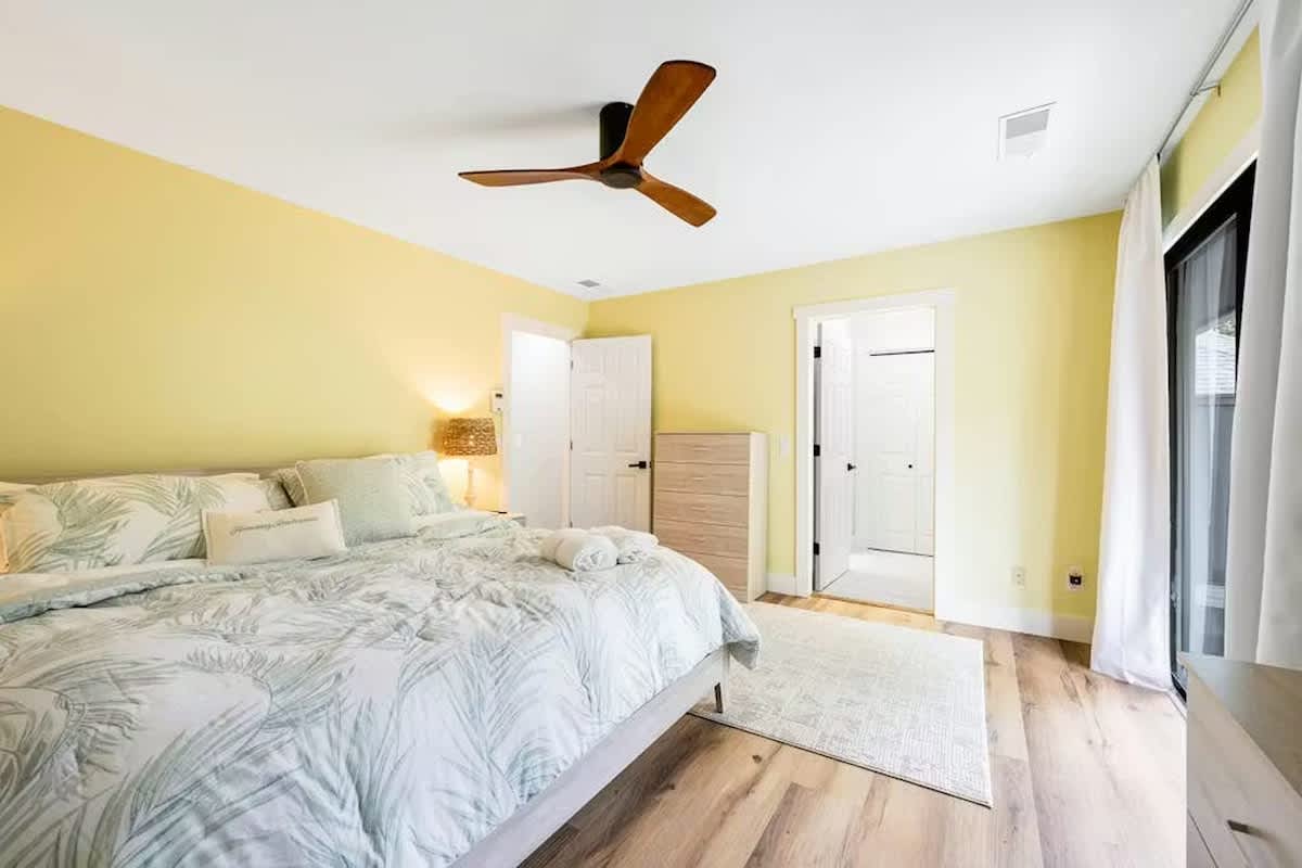 Wake up refreshed in this bright, airy bedroom with cheerful yellow walls and tropical bedding that sets a peaceful tone for your stay.