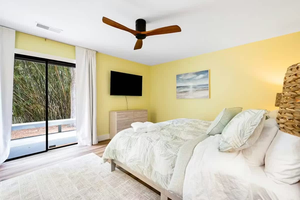 Drift off in this sunny bedroom with crisp linens, tropical views, and a soothing coastal breeze from your ceiling fan.