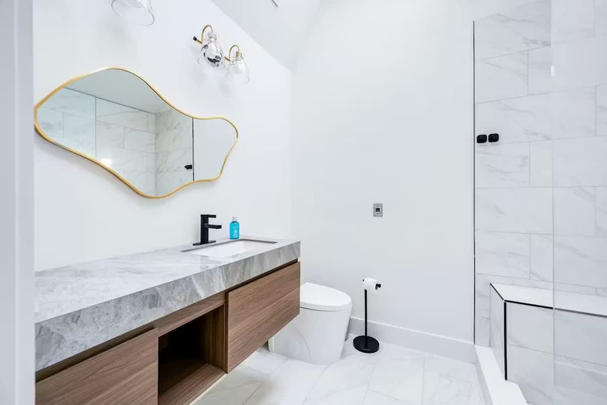 Indulge in your private spa-like bathroom with marble counters, modern fixtures, and a luxurious glass-enclosed shower.