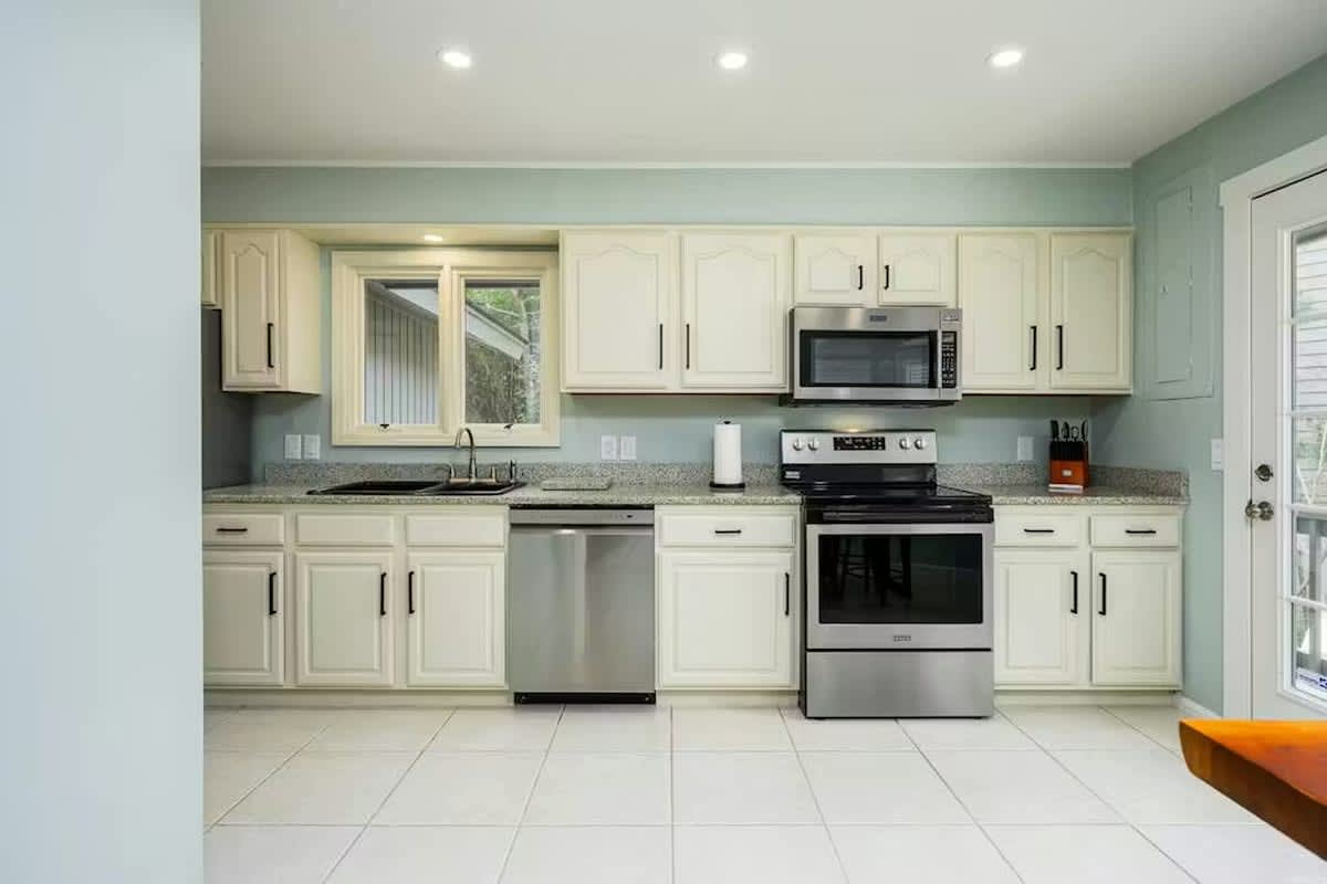 Your fully equipped kitchen awaits with modern stainless steel appliances, granite countertops, and bright white cabinetry for all your culinary adventures.