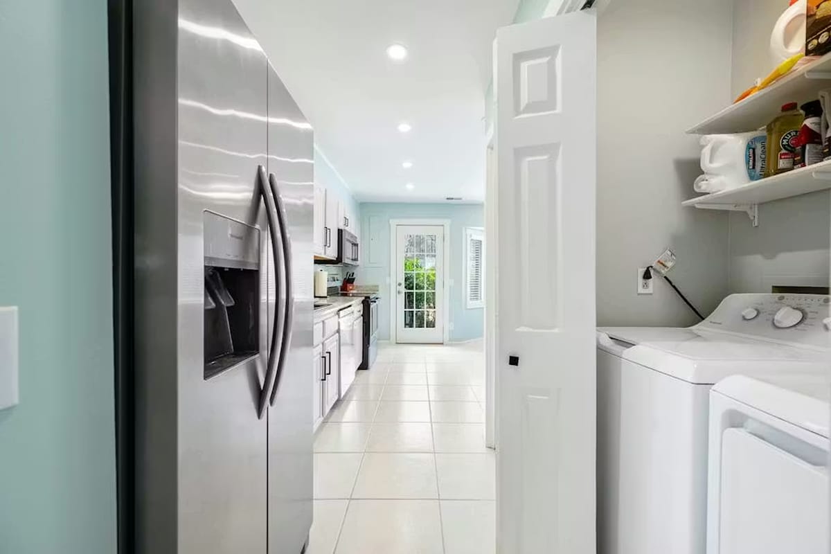 Your bright, modern kitchen connects seamlessly to a convenient laundry area, making meal prep and daily chores effortless during your stay.