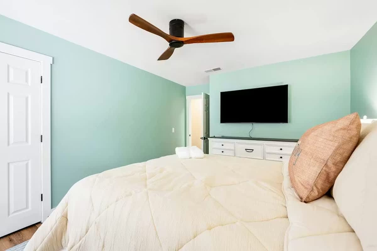 Rest peacefully in your serene bedroom with calming mint walls, plush bedding, and entertainment at your fingertips.