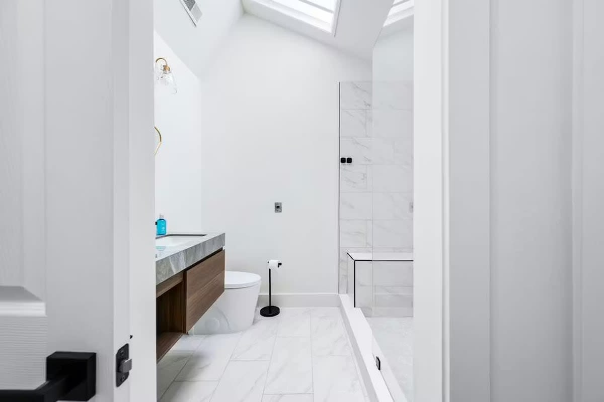 Unwind in your sleek, marble bathroom featuring a luxurious walk-in shower and modern fixtures bathed in natural light.