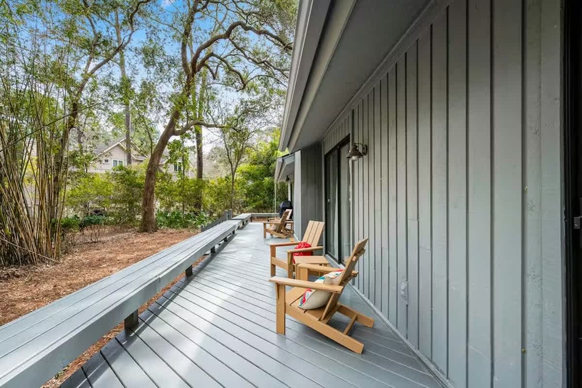 Step onto your private deck and sink into teak Adirondack chairs, where morning coffee tastes better surrounded by towering trees and peaceful garden views.