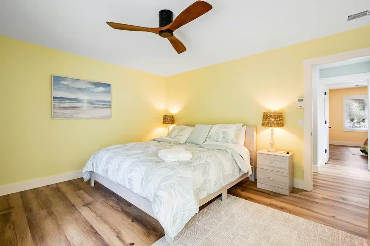 Drift off in your sunny bedroom with coastal vibes, soft linens, and warm wood floors keeping you comfortable.