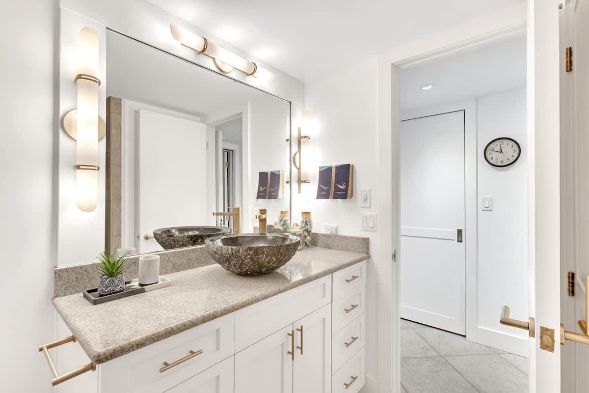 Pamper yourself in this stunning bathroom featuring elegant vessel sinks, warm lighting, and luxurious finishes for your ultimate comfort.