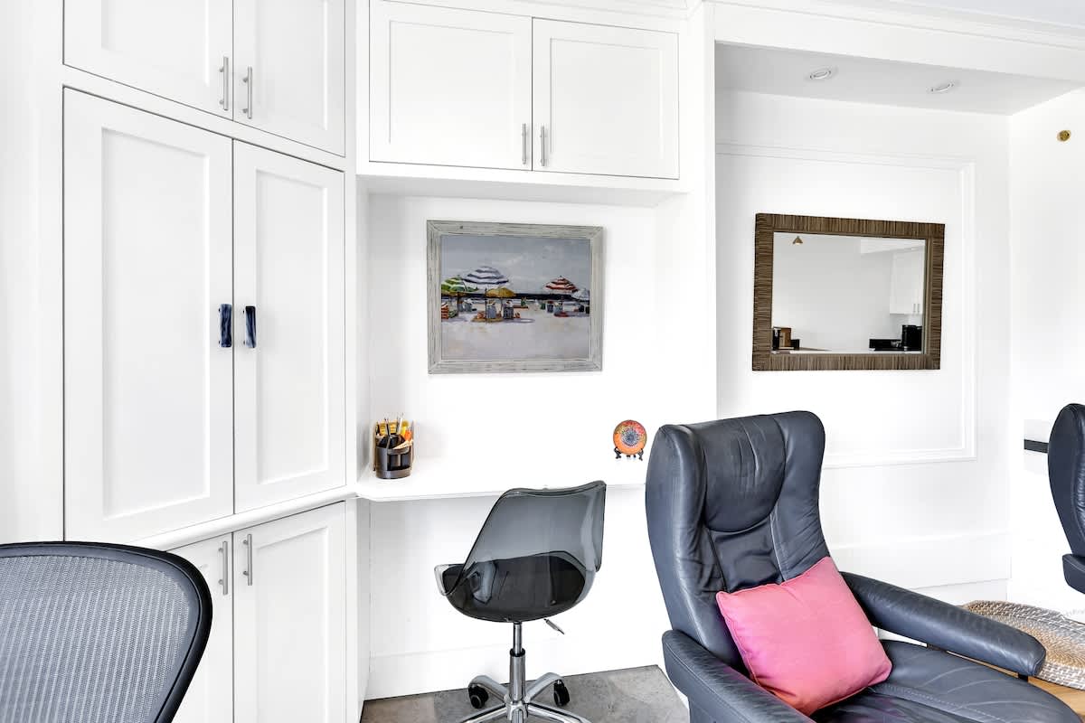Settle into your stylish office space with custom white storage and comfy leather seating for productive work days.