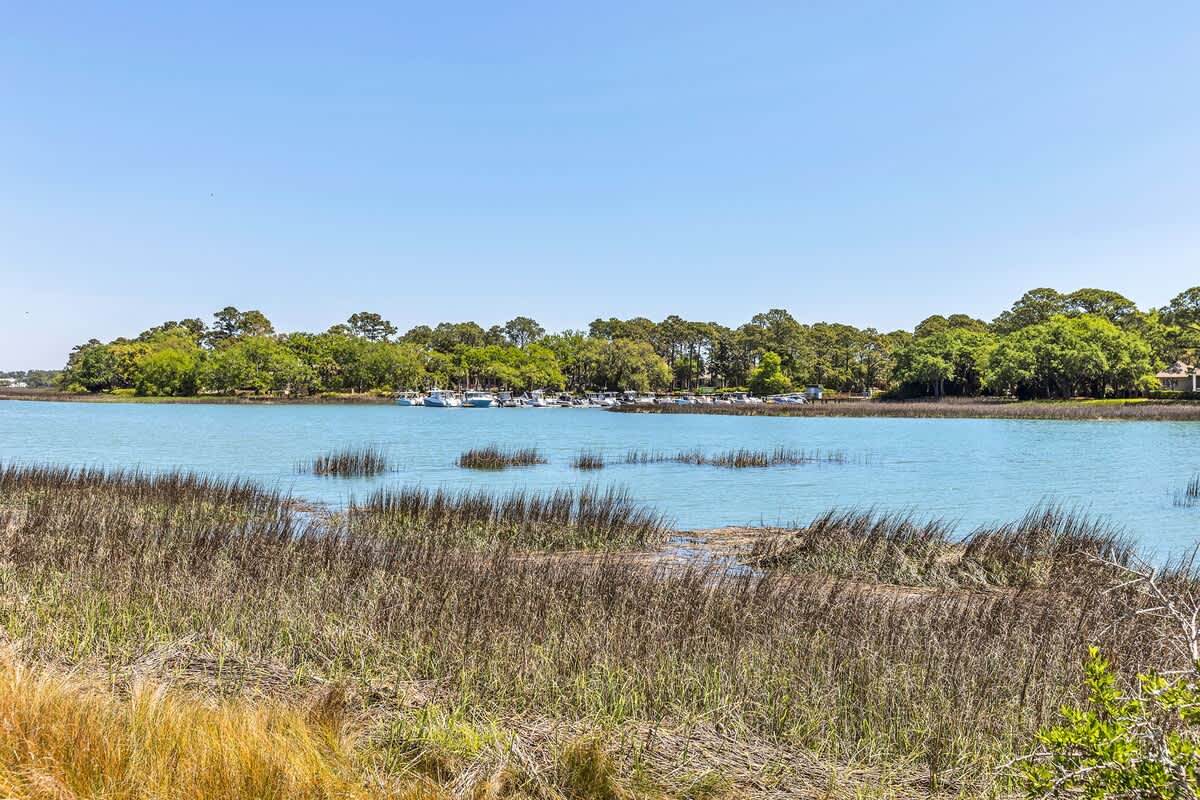 Tranquil coastal waters meet lush marshlands and marina views in this peaceful waterfront setting.