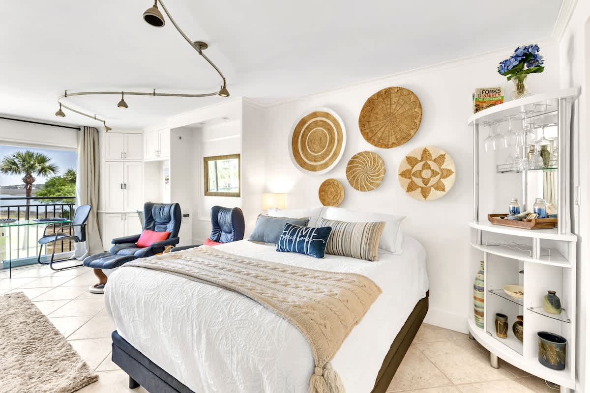 Drift off to sleep in your coastal haven with handwoven basket art above the plush bed and poolside balcony doors that invite morning breezes.
