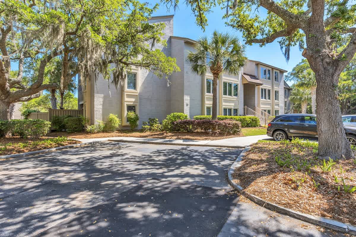Modern coastal property nestled among majestic oak trees with convenient parking and landscaped grounds.