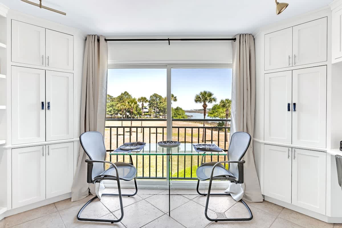 Your bright dining space opens to a serene water view, where morning coffee tastes better with palm trees swaying outside your window.