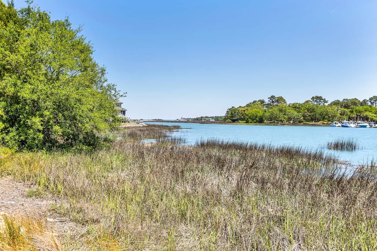 Tranquil waterfront setting with pristine marshlands and peaceful marina views creating a serene coastal atmosphere.
