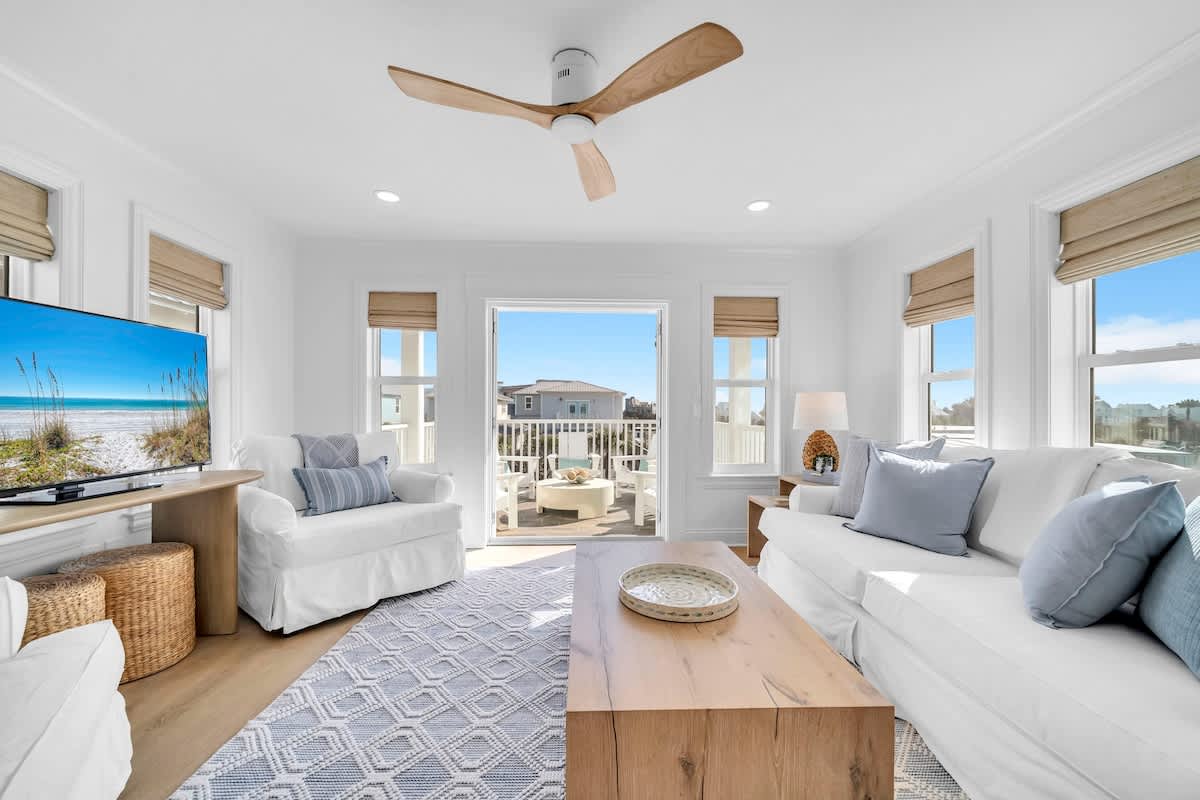 Third floor living space with smart tv and access to private deck with seating.