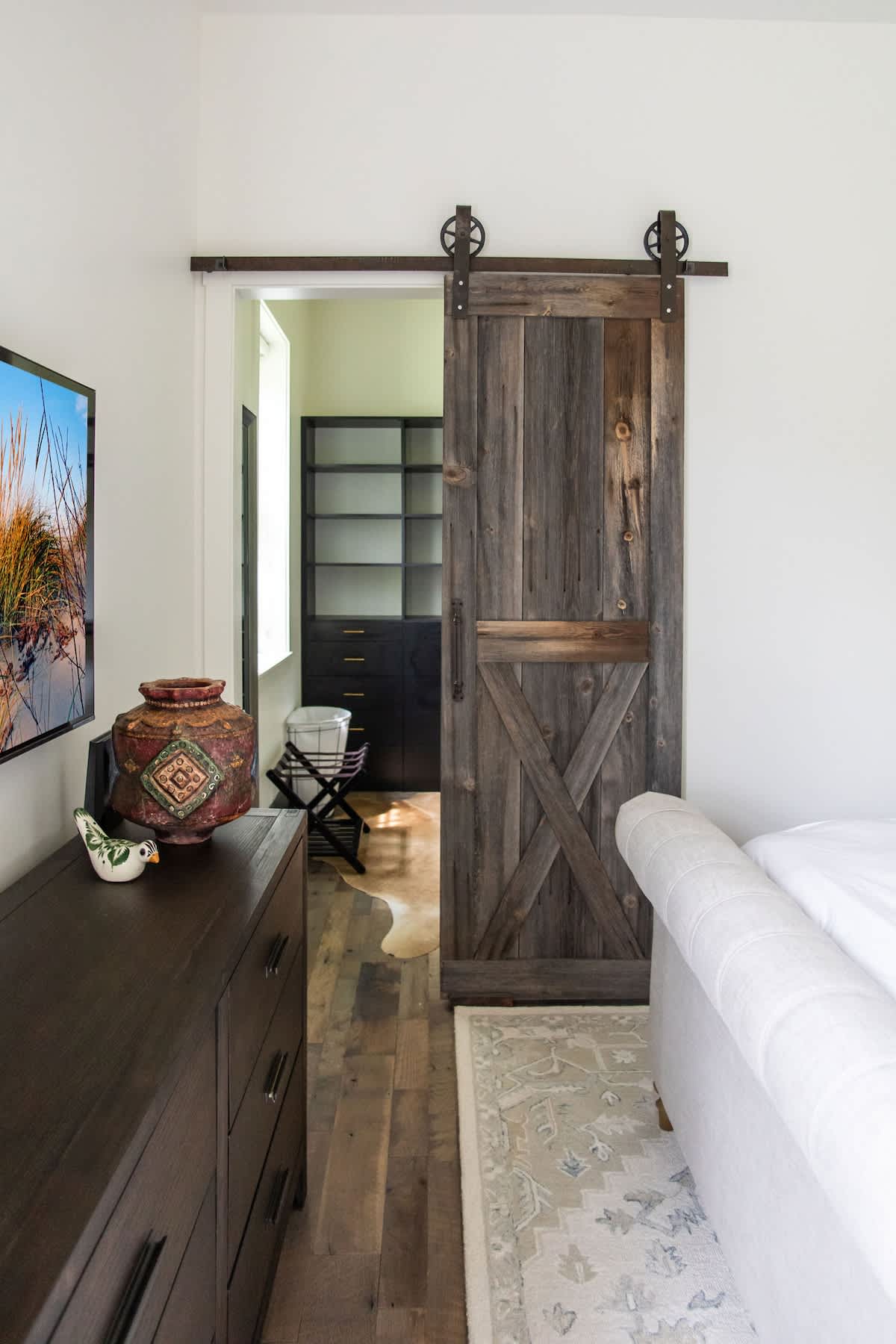 A classic barn door leads to the main bedroom’s closet.