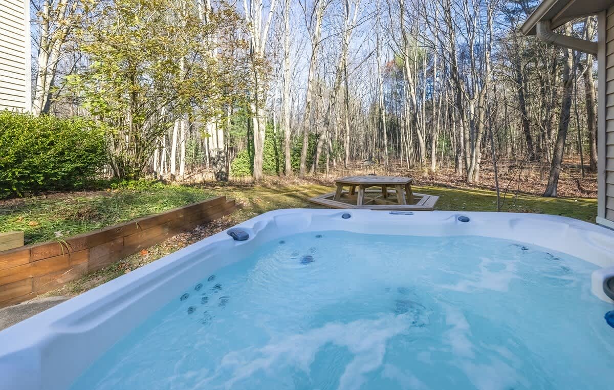 Unwind in the bubbling hot tub with serene woodland scenery.