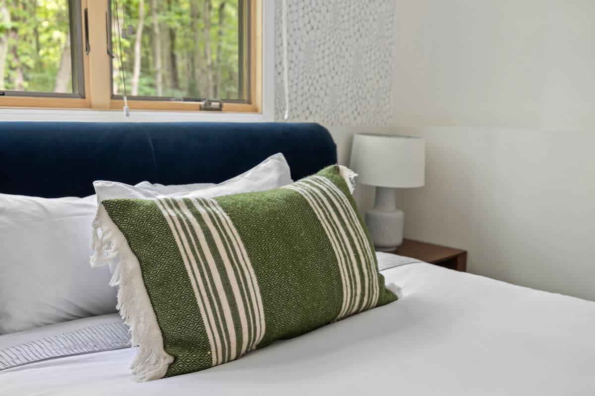 A queen bed warmly greets guests in the second bedroom.