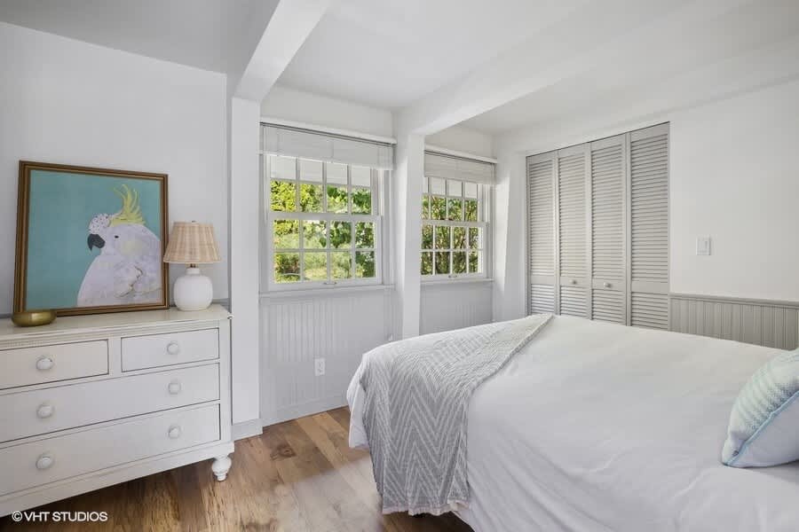 Embracing the minimalist aesthetic in my white bed and wooden floor bedroom.