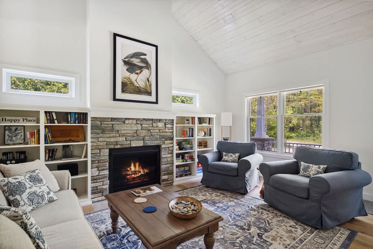 Lounge in the cozy living area with stone-trimmed fireplace in chillier weather.