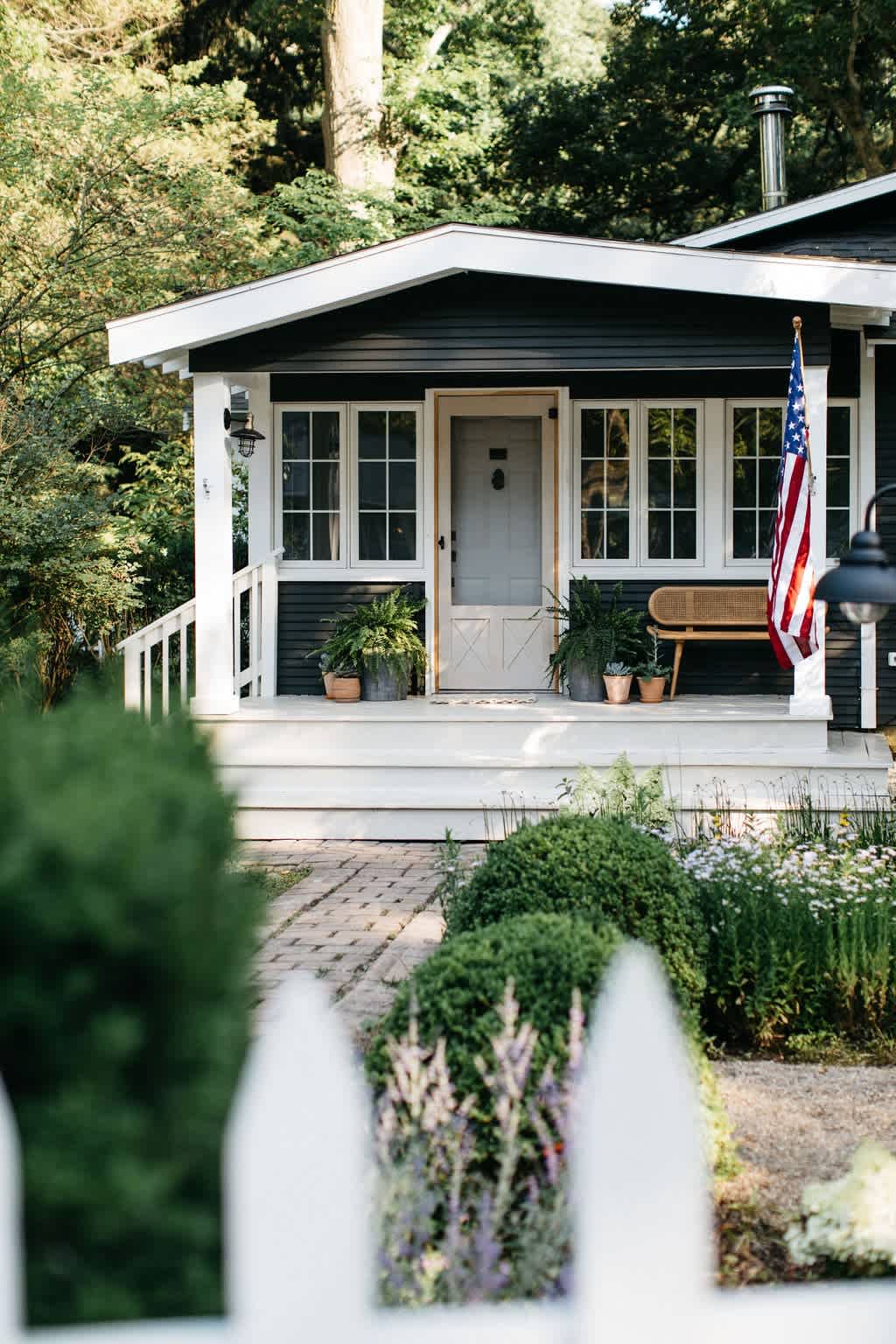 The cottage exterior greets guests with a charming wood picket gate