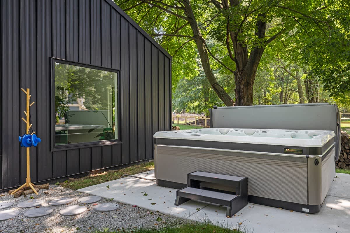 Surrounded by lush greenery, the hot tub offers a peaceful spot to relax and unwind.