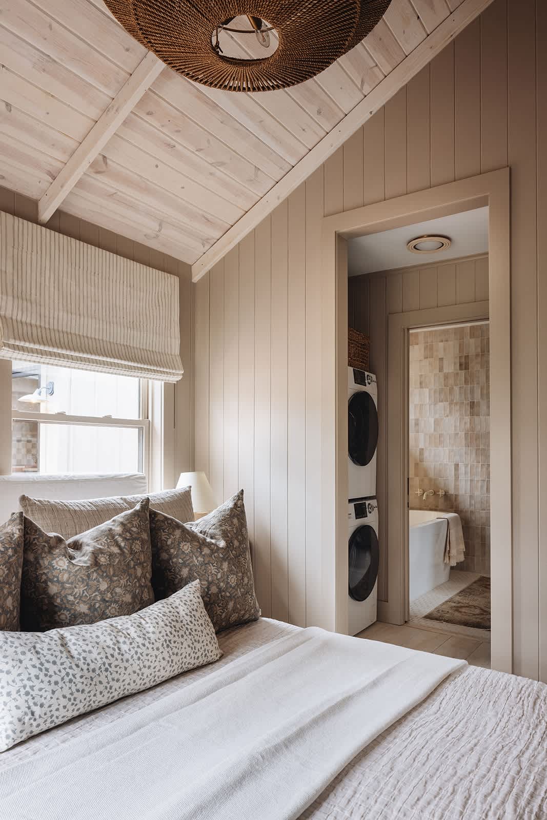 This bedroom has a chic Ensuite bathroom including a stacked washer-dryer combo.