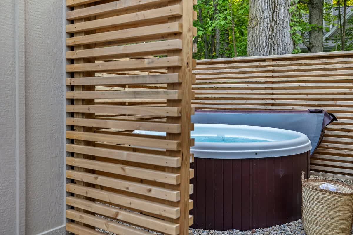Relaxing in the backyard hot tub, surrounded by a cozy wooden fence.