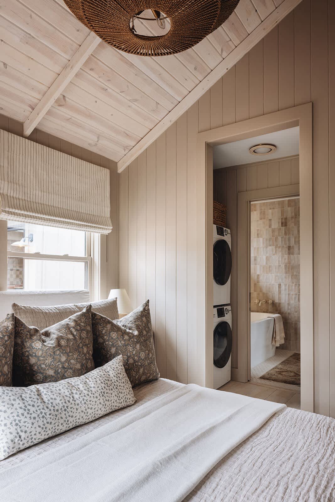 This bedroom has a chic Ensuite bathroom including a stacked washer-dryer combo.