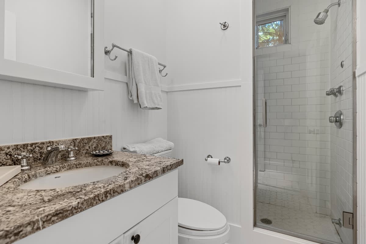 Transform your bathroom into a sanctuary with white cabinets and a luxurious shower stall.