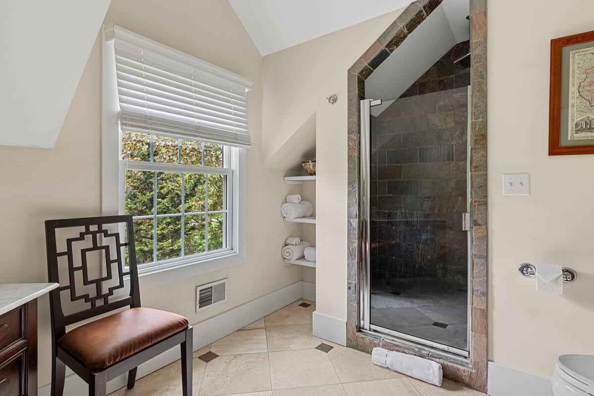 Y'all be lovin' this spacious stone-tile walk-in shower with a Rain-Shower head.