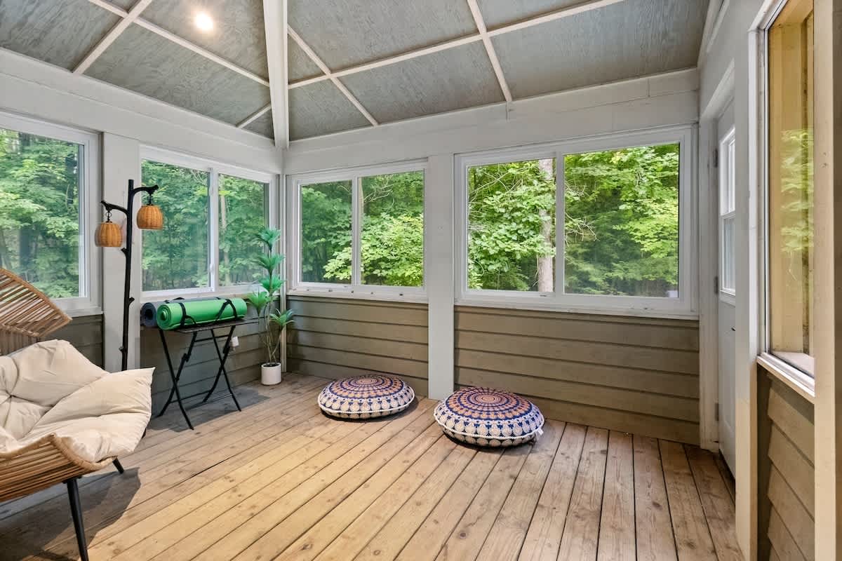 Find your zen in this serene forest-view sunroom.