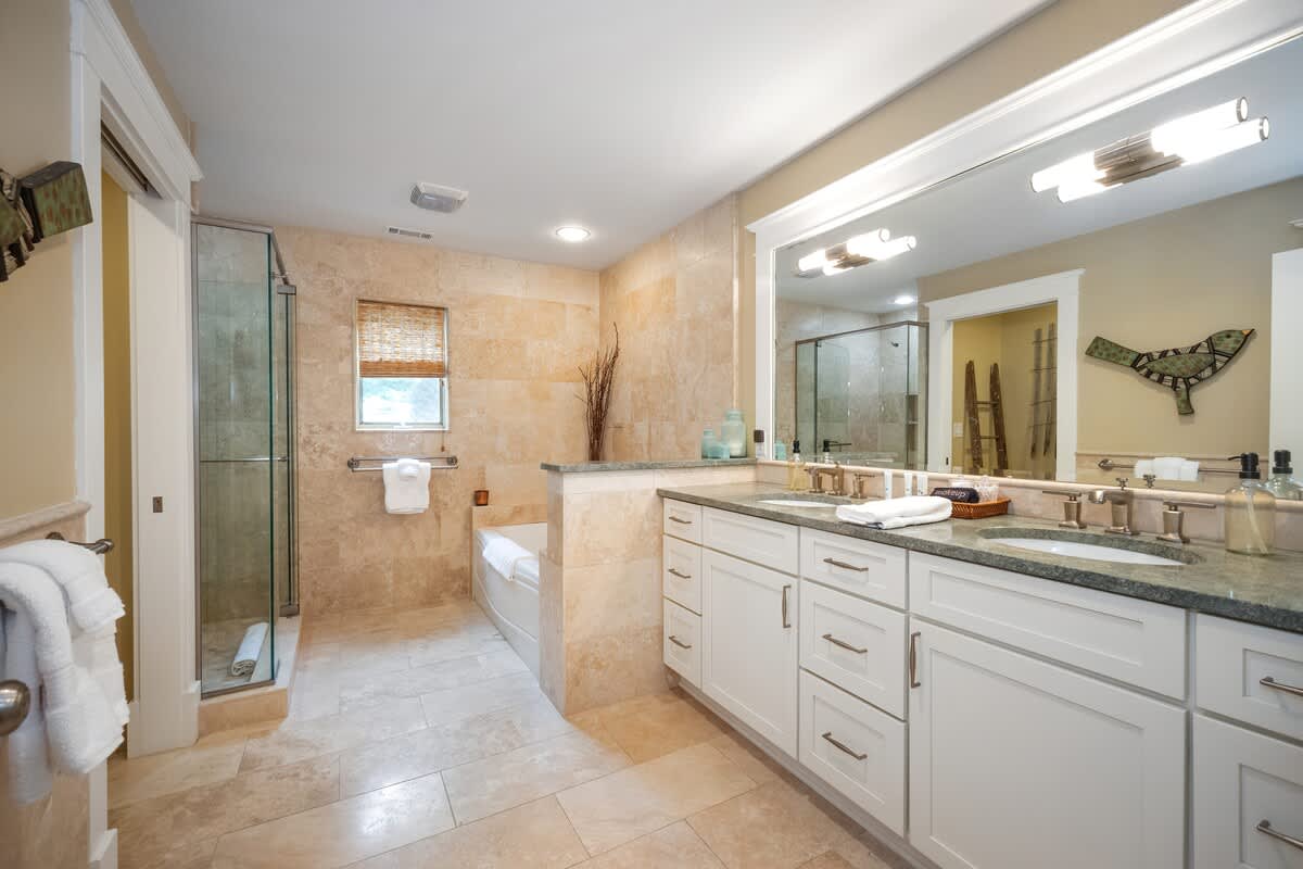 The Master Bathroom includes a chic tiled walk-in shower, tub + 2 vanity sinks.