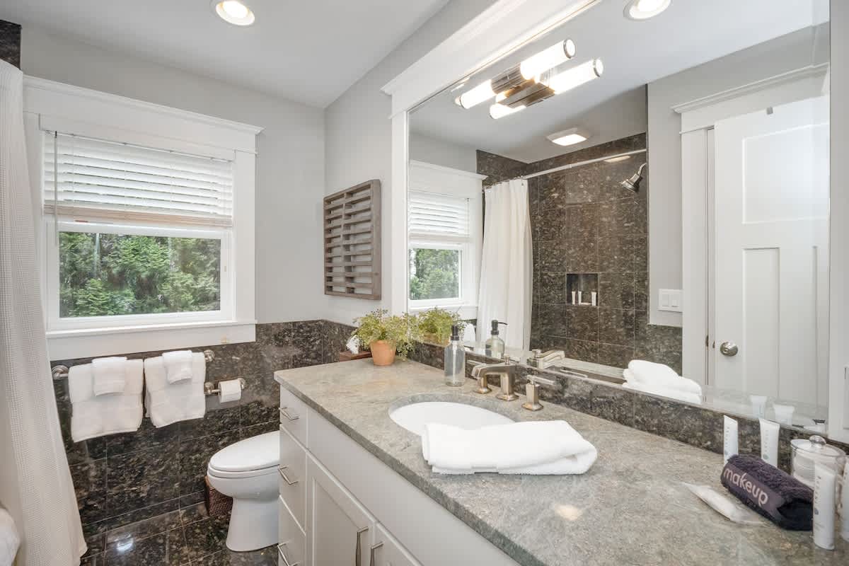 The main floor hallway bathroom features a deluxe vanity and shower-tub.