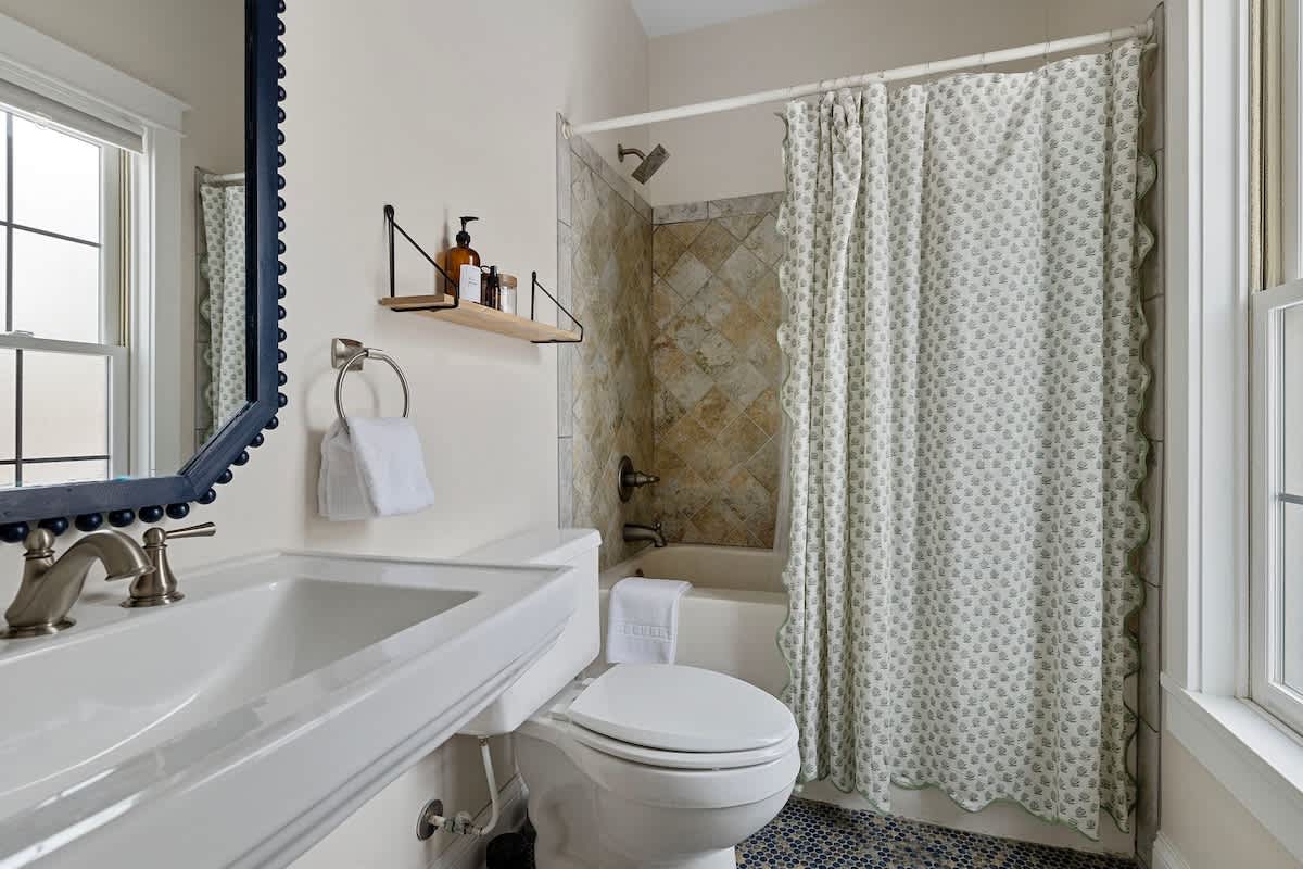 Well-lit bathroom with a gorgeous vanity + tiled tub-shower. What's not to like?