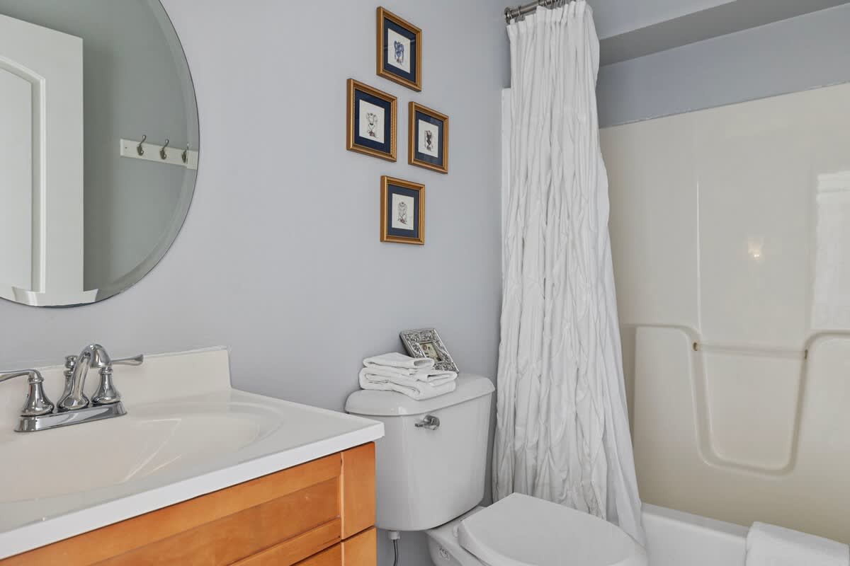 This handsome bathroom is equipped with all the essentials and has a tub-shower.