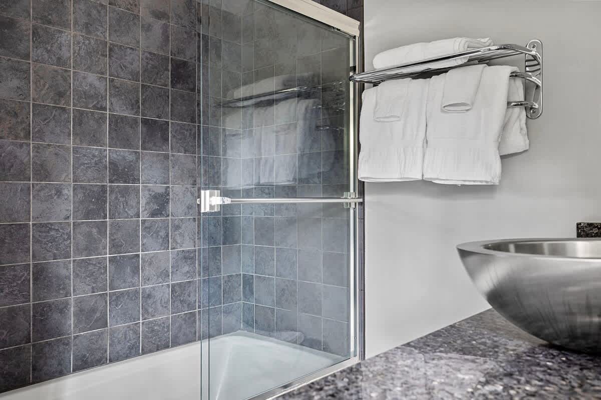 A special touch in this posh bathroom is its steel-bowl, stone-top vanity sink.