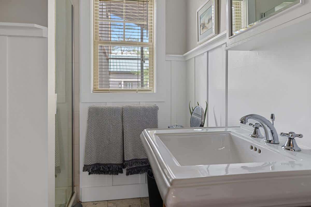 The renovated bathroom features marble-and-beach-pebbled flooring.