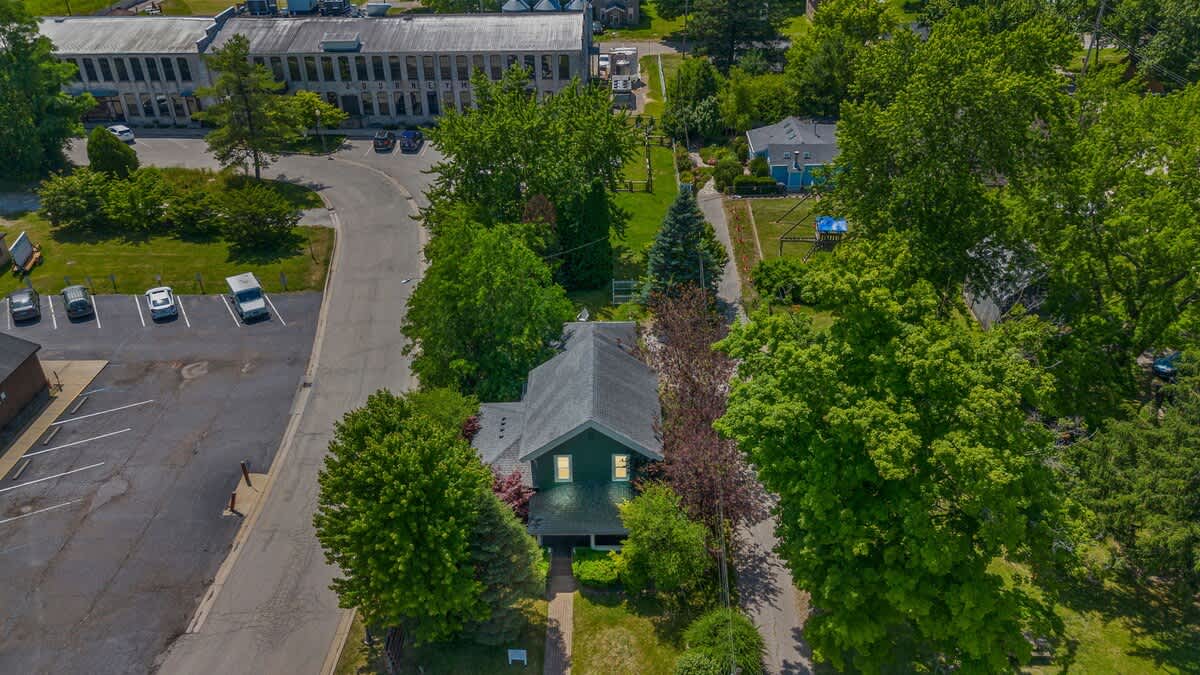 Elevate your perspective with this breathtaking aerial shot of a charming residential neighborhood. The vibrant trees and busy streets below showcase the perfect blend of nature and modern living.