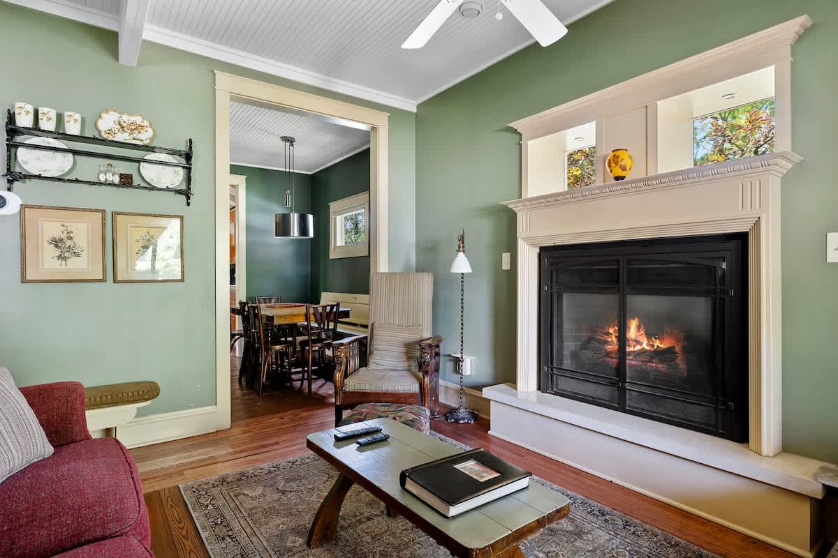 A cozy nook by the fireplace, leading to a charming dining area.