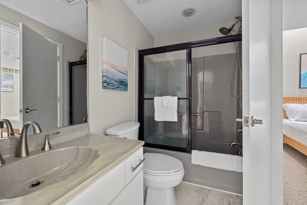 Fresh towels, sleek fixtures, and ocean art to keep the beach close, even indoors.