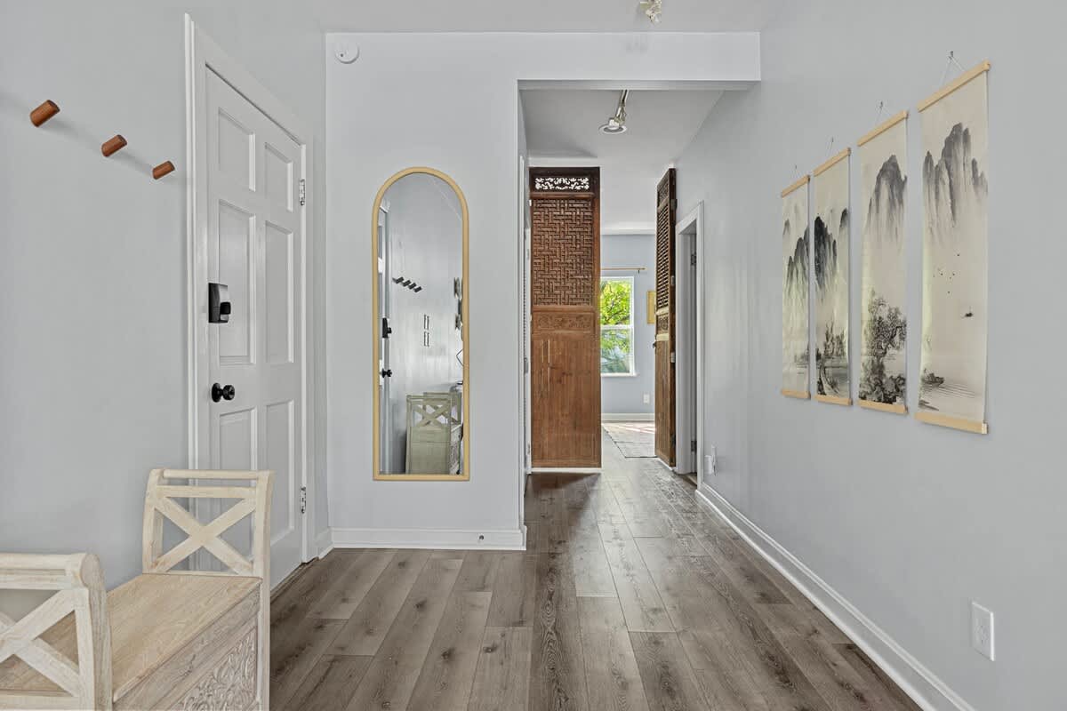 Find your inner peace in this charming hallway featuring a wooden bench and a mirror.