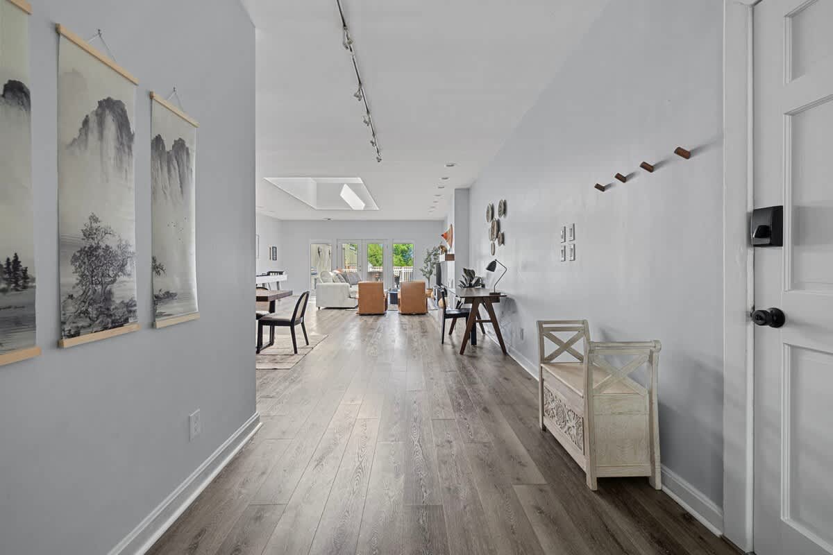 Walking through this sleek hallway with a white wall and wooden floors.