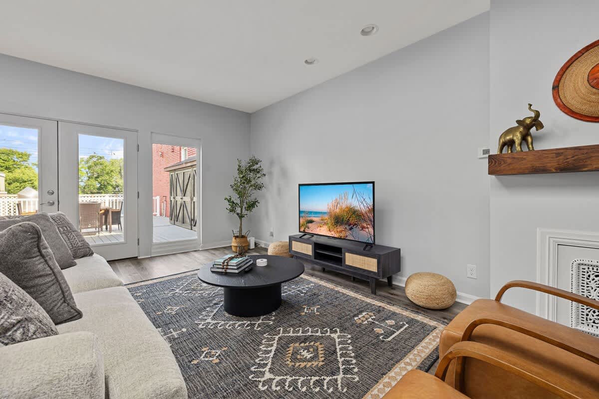 Indulge in the opulence of this sophisticated living space with a cozy couch, chic chair, and high-end TV.