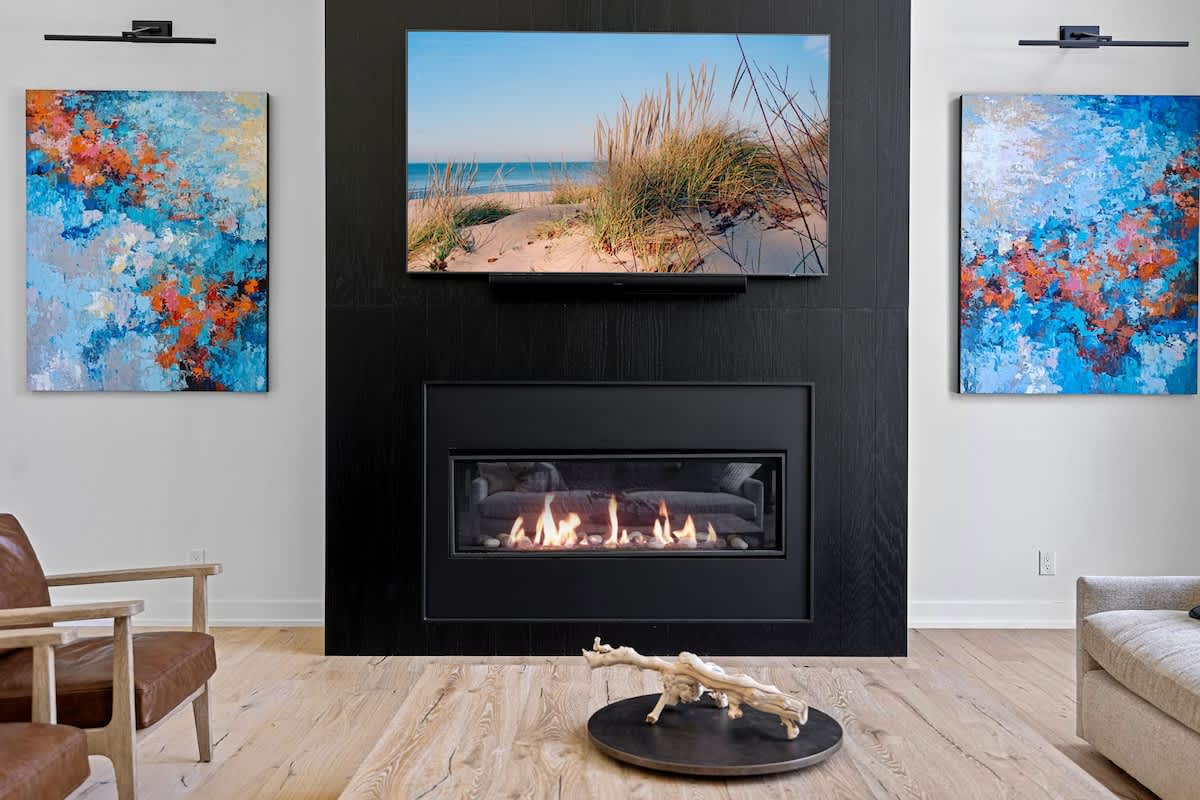 Ignite your creativity in this contemporary living room adorned with beautiful artwork and a warm fireplace.