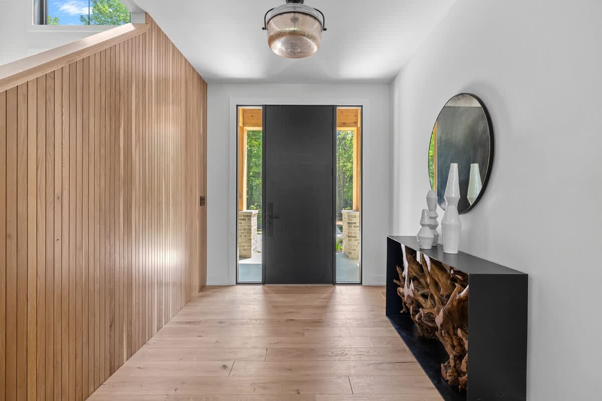 Enter the enchanting hallway with rustic wooden walls and a mysterious black door.