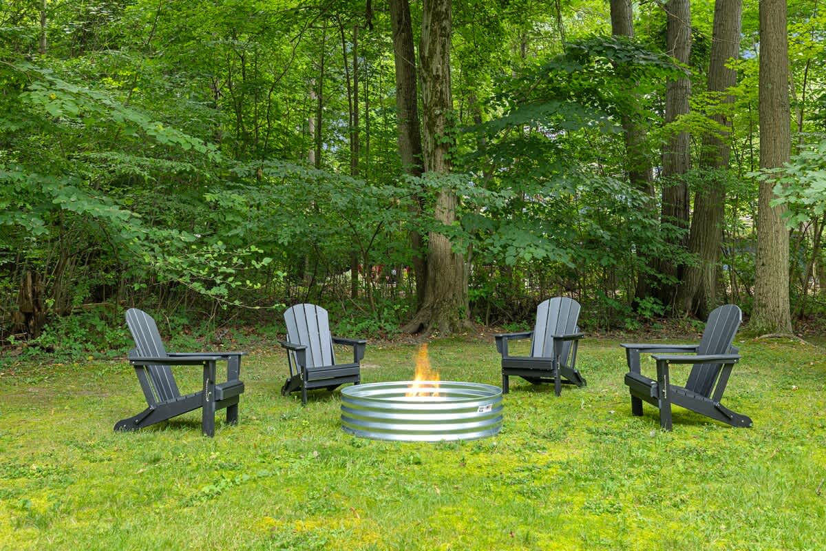 Relax in Adirondack chairs by the firepit, surrounded by nature.