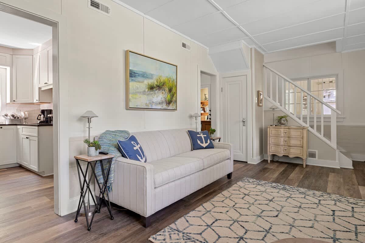 A blend of classic and coastal: the striped couch and anchor pillows offer a fresh, breezy feel, while the rustic chest adds a dash of vintage charm.
