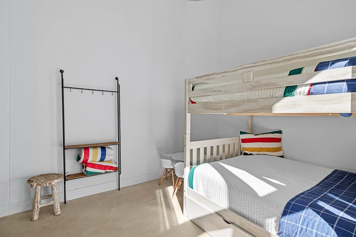 Stylish bunk room with cozy beds and soft natural light.