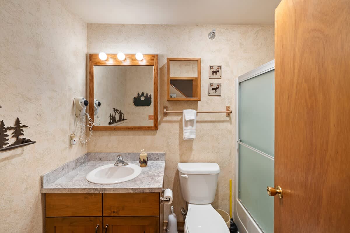 This bathroom setup is perfect for unwinding after a long day. Sink, shower, and toilet—everything in one serene space.