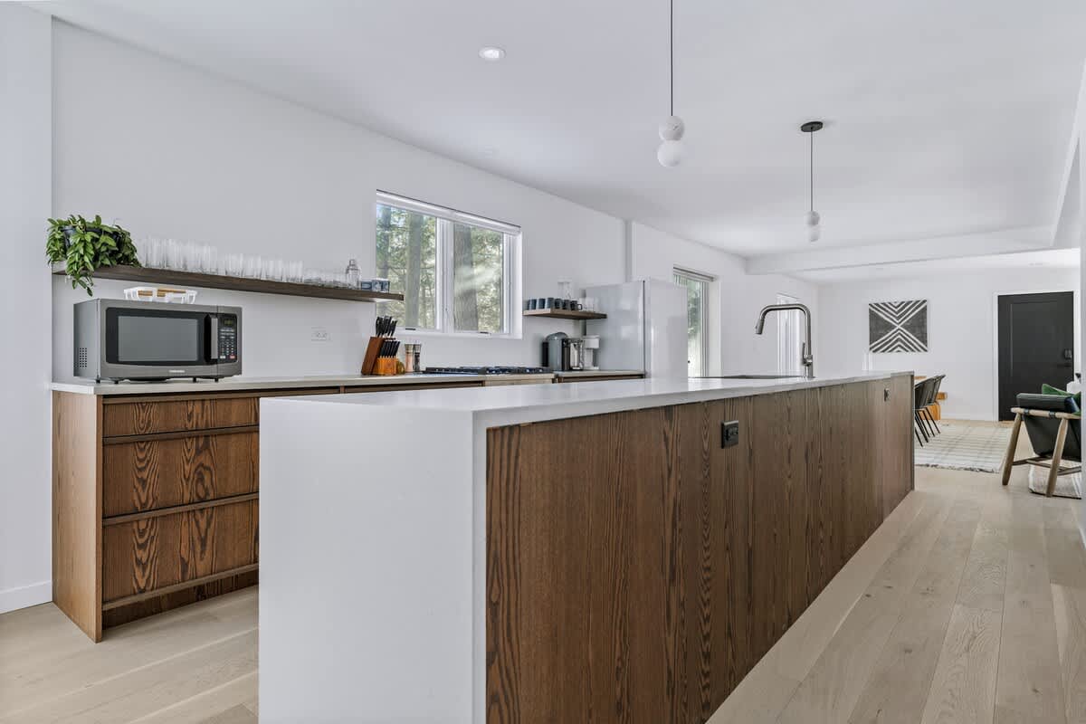 Sleek surfaces, warm wood accents, and endless counter space—this kitchen is the heart of modern elegance.