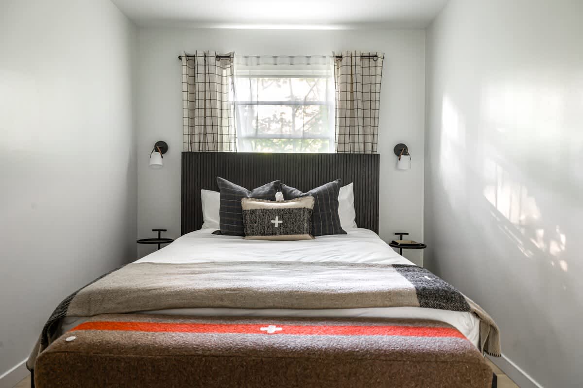 Plaid, patterns, and the perfect pop of color—this bedroom is chef’s kiss cozy.
